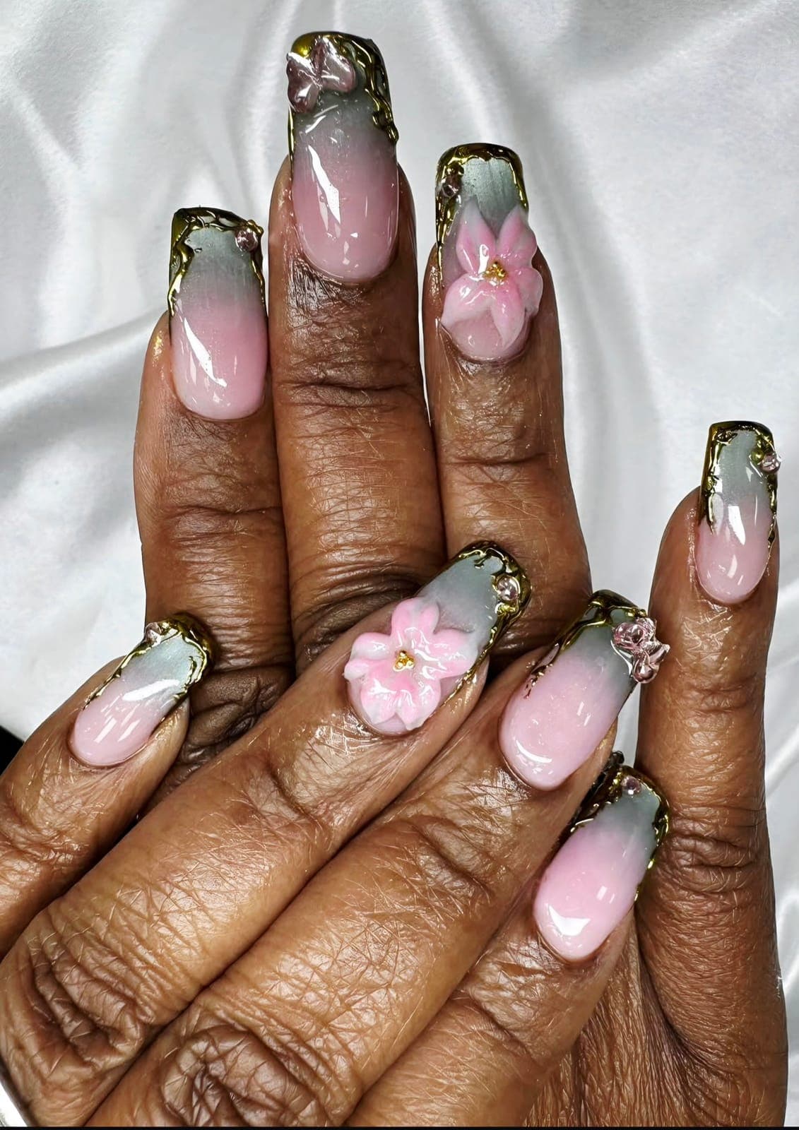 Pink nails with gold-edged French tips and a 3D flower